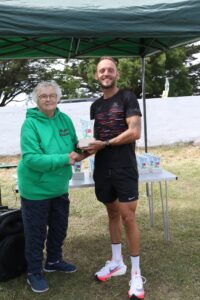 Chris Weeks picks up his trophy for winning the Portland 10
