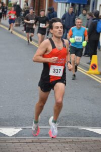 Christopher Peck crossing the line in the Junction Broadstone Quarter Marathon
