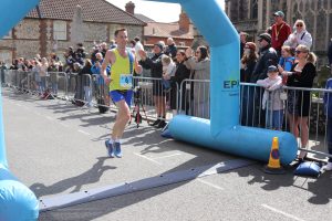 Stu Nicholas crossing the line in the Norfolk Marathon